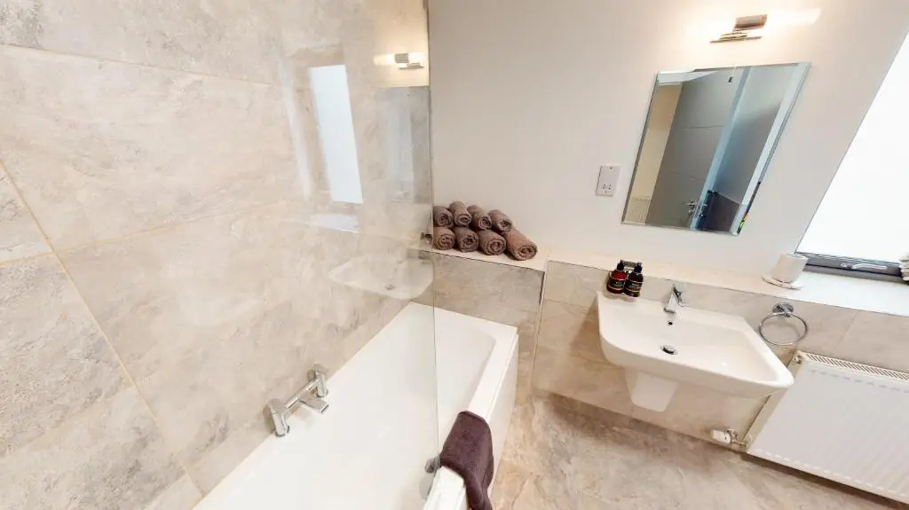 a bathroom with a sink and a tub and a mirror at Alpine View - a cosy Aviemore House in Aviemore