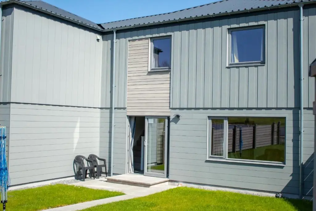 a house with two benches in front of it at Alpine View - a cosy Aviemore House in Aviemore