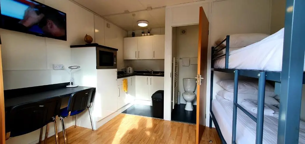 a small room with two bunk beds and a desk at Kingussie Garden Cabins in Kingussie