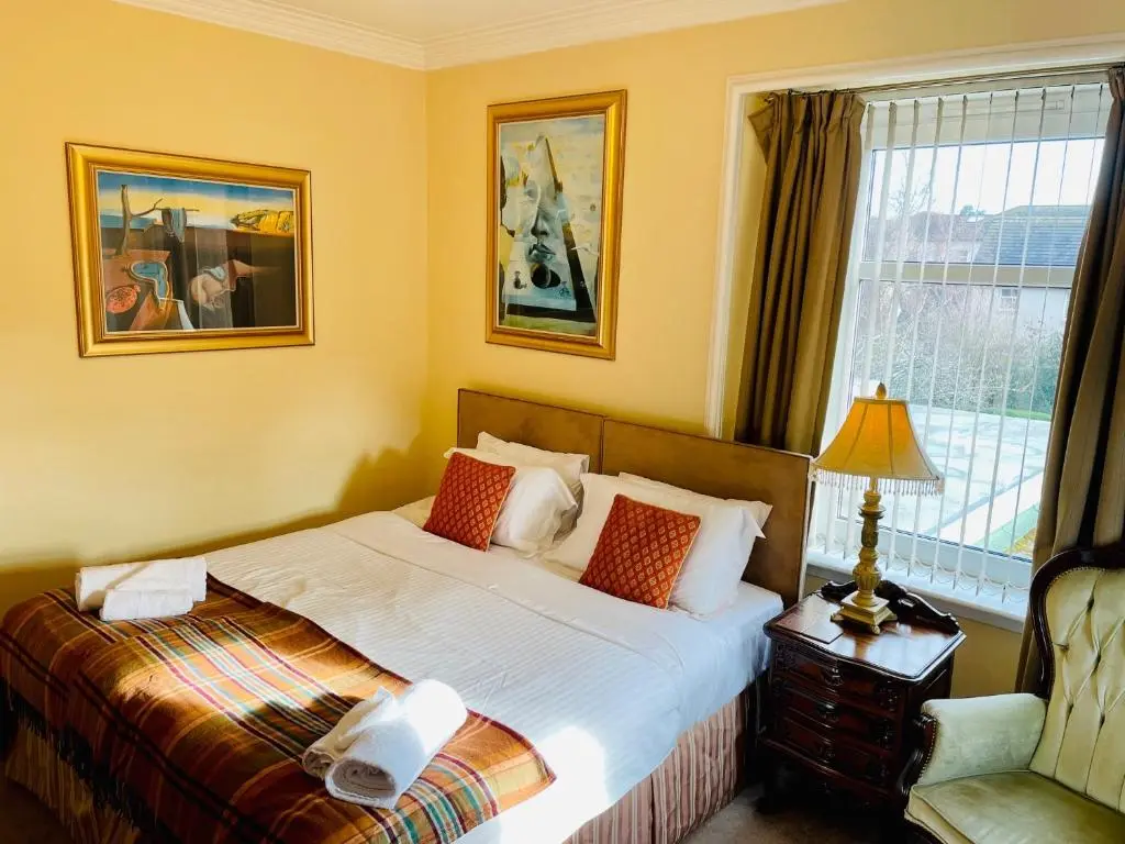 a hotel room with a bed and a window at Ladies Lodge Inverness in Inverness