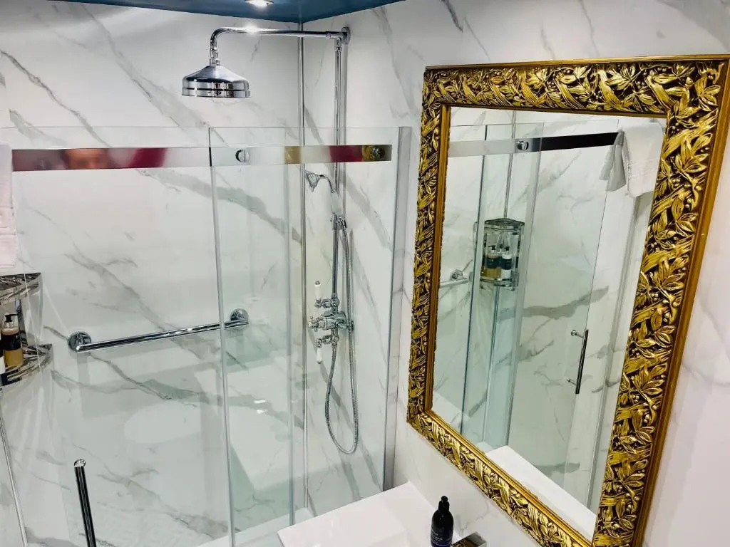 a bathroom with a shower with a mirror at Ladies Lodge Inverness in Inverness