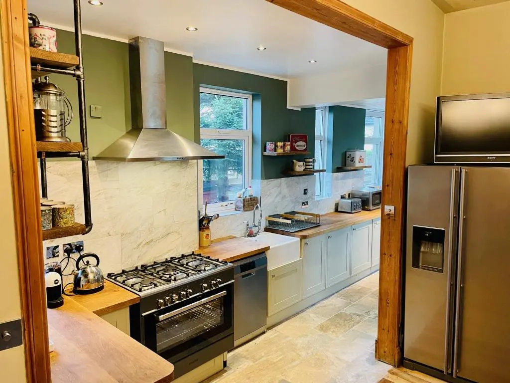 a kitchen with a stove and a refrigerator at Ladies Lodge Inverness in Inverness