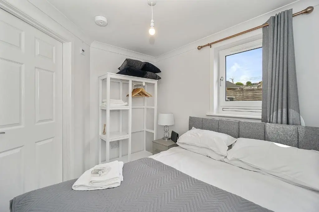 a white bedroom with a bed and a window at Modern seaside apartment ,Lossiemouth, Moray in Lossiemouth