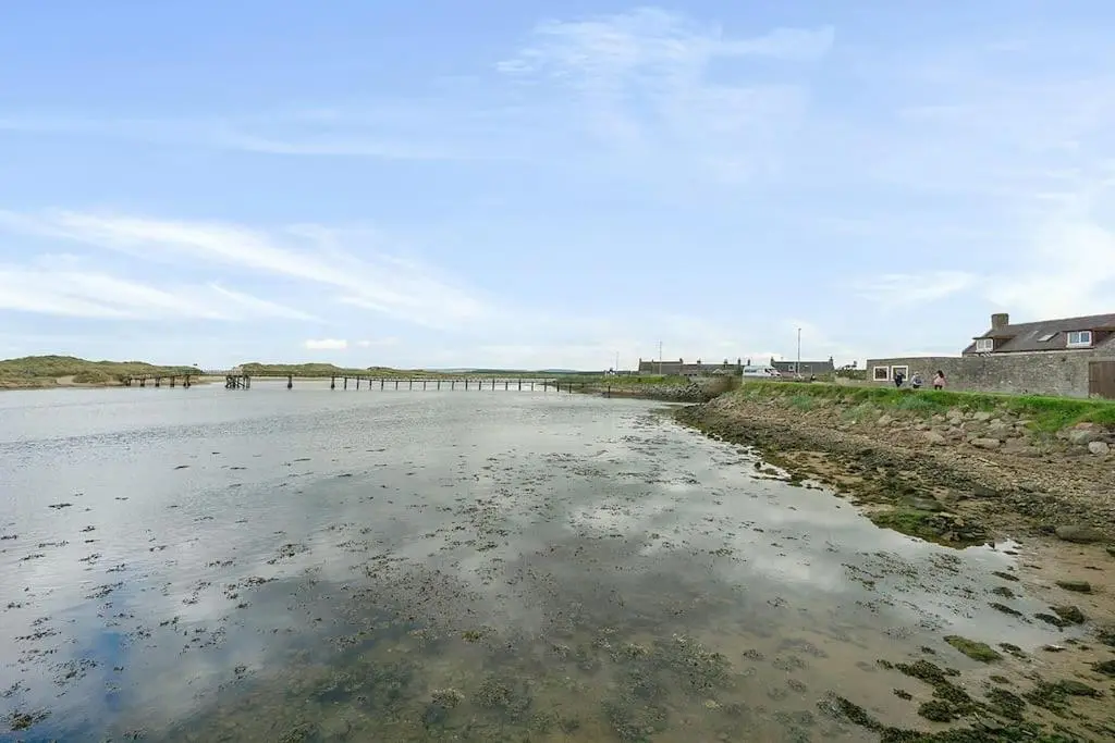 a body of water with a pier in the distance at Modern seaside apartment ,Lossiemouth, Moray in Lossiemouth