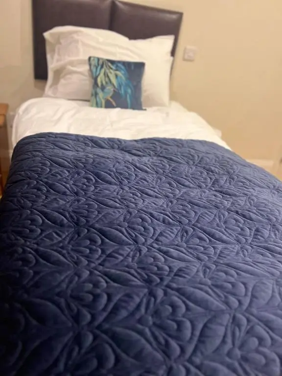 a blue comforter on a bed in a room at The Aberlour Hotel in Aberlour