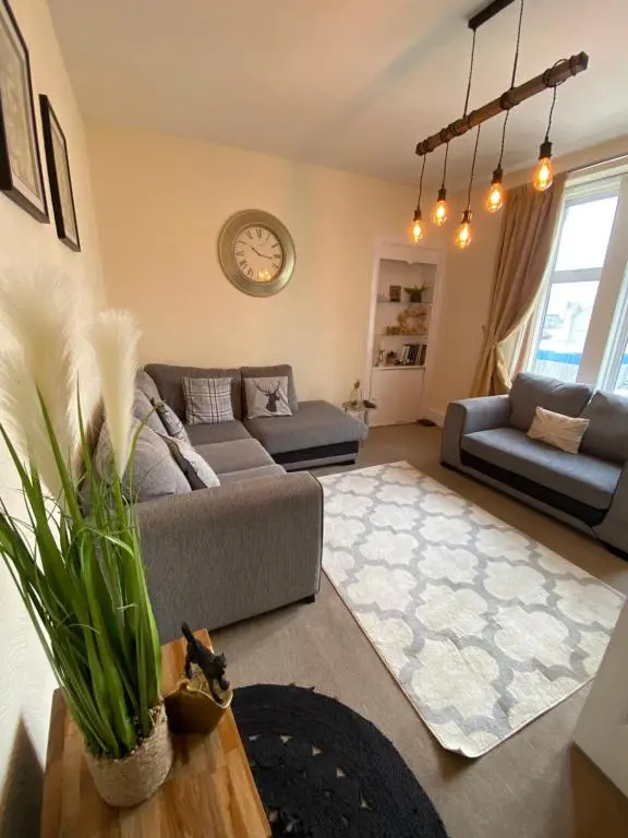 a living room with a couch and a table at Inverness city apartments - Innes in Inverness
