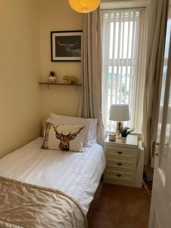 a bedroom with a bed with a deer head on the pillow at Inverness city apartments - Innes in Inverness