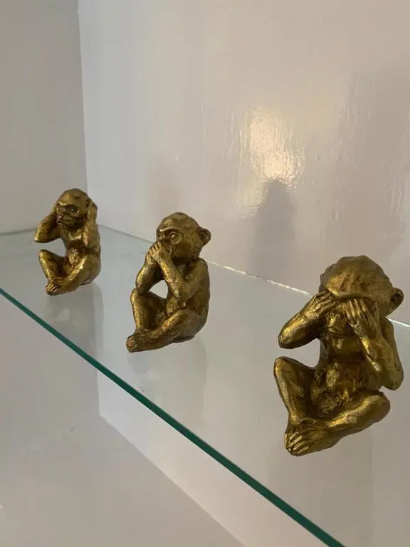 three bronze figurines of dogs sitting on a glass shelf at Inverness city apartments - Innes in Inverness
