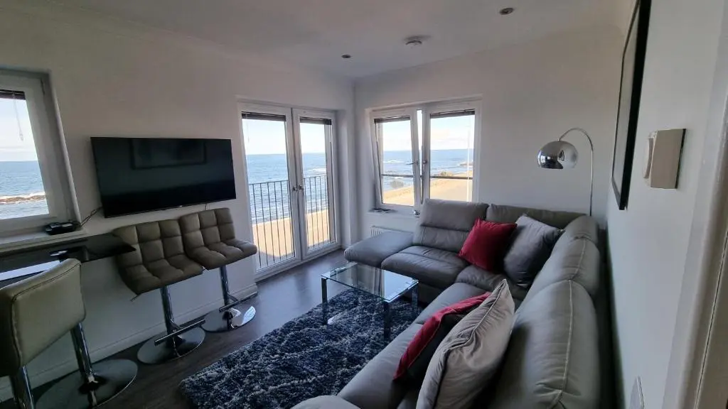 a living room with a couch and a flat screen tv at 22 Waters Edge Banff in Banff