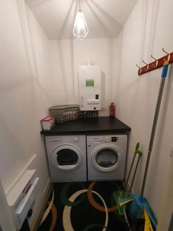 a laundry room with a washing machine and a coffemaker at 22 Waters Edge Banff in Banff