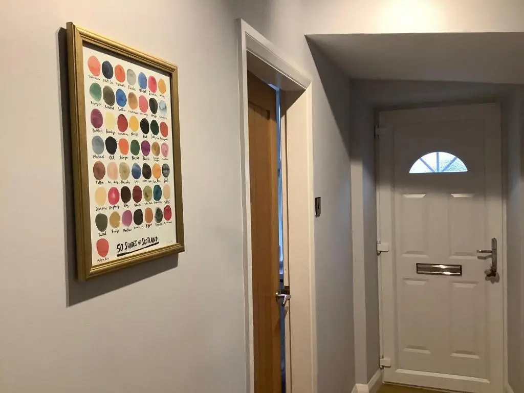 a painting hanging on a wall next to a door at 4 Stills Apartment in Rothes