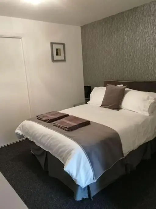 a bedroom with a large bed with two towels on it at Avalon Studio. Comfy well equipped cosy studio. in Aviemore