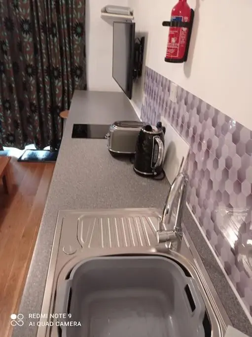 a kitchen counter with a sink and a stove at Avalon Studio. Comfy well equipped cosy studio. in Aviemore