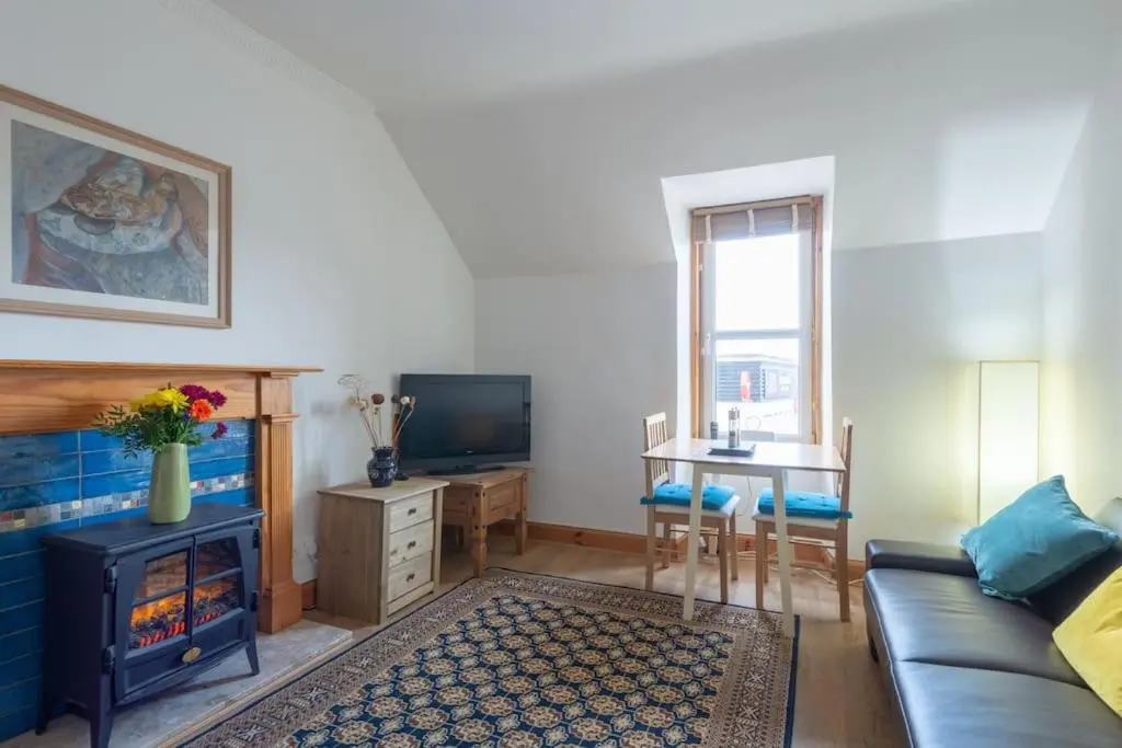 a living room with a couch and a fireplace at The 'Fairy Hill' Apartment in Inverness