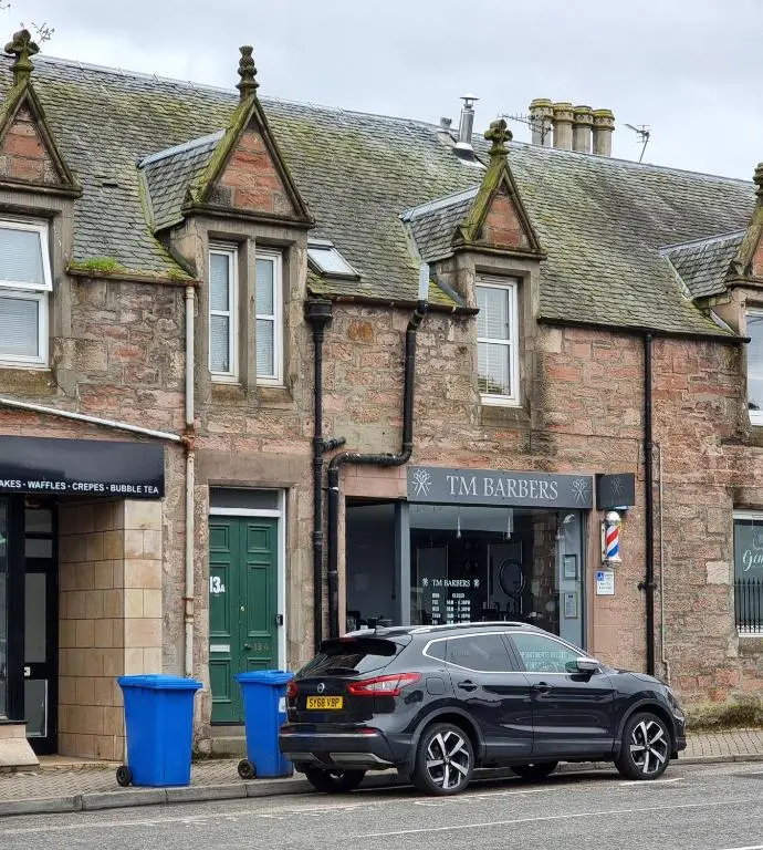 a black car parked in front of a building at The 'Fairy Hill' Apartment in Inverness