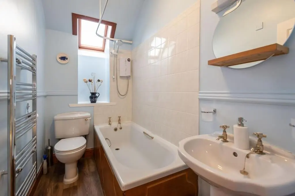 a bathroom with a sink and a toilet and a tub at The 'Fairy Hill' Apartment in Inverness