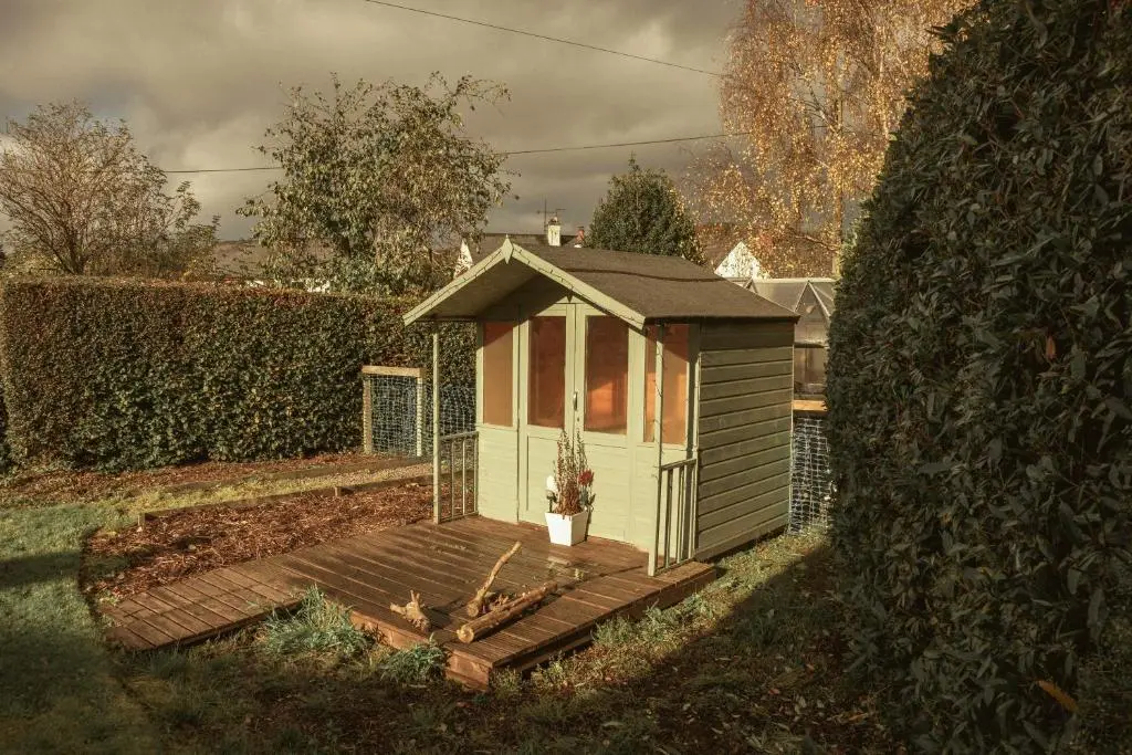 a small shed with a wooden deck in a yard at No 4 the Highlands in Strathpeffer