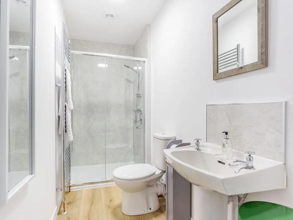 a bathroom with a sink and a toilet and a shower at New Cottage in Farr