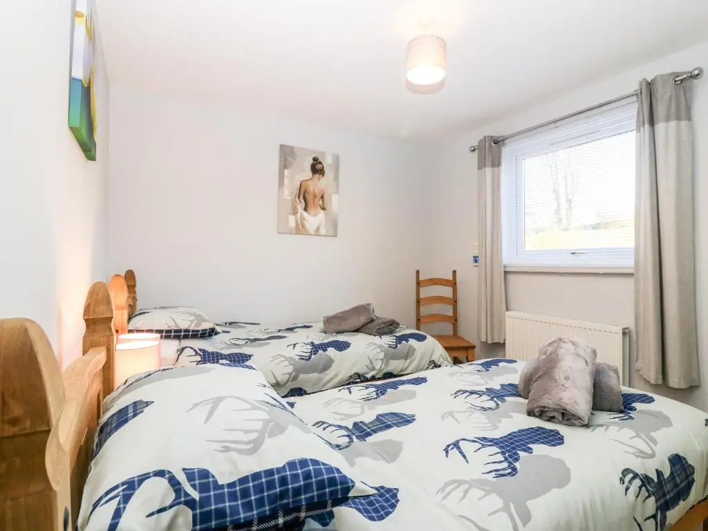 a bedroom with two twin beds and a window at 10 Annesley Park in Banchory