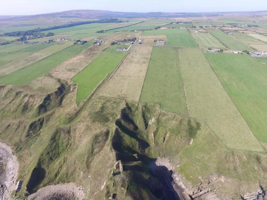 an aerial view of green fields on a mountain at Castle Shieling in Latheron