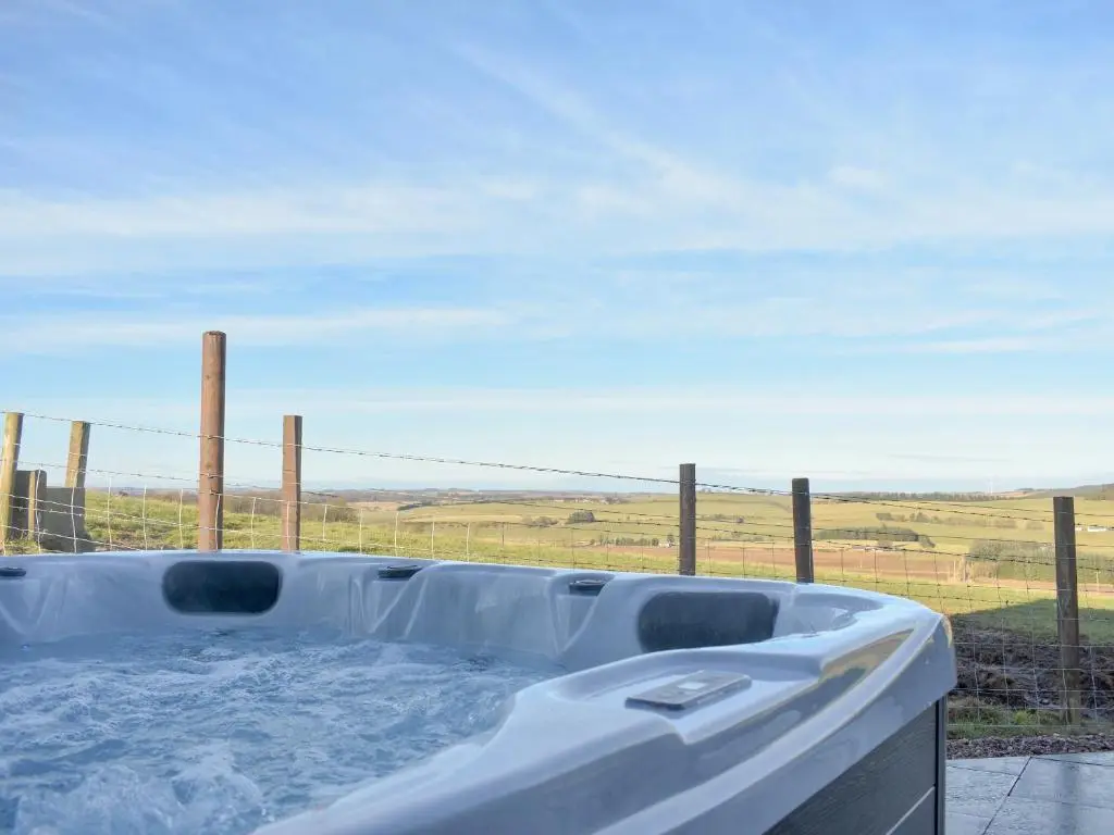 a bath tub with a view of a field at Benwells Holiday Cottage in Maud