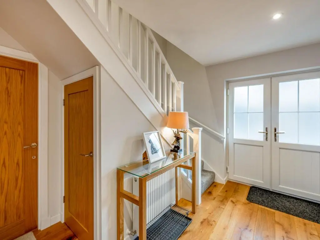 a room with a staircase and a table with a lamp at Holiday Home Loch Ness House by Interhome in Drumnadrochit