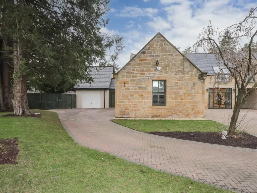 a brick house with a brick driveway at 1 The Coach House in Elgin