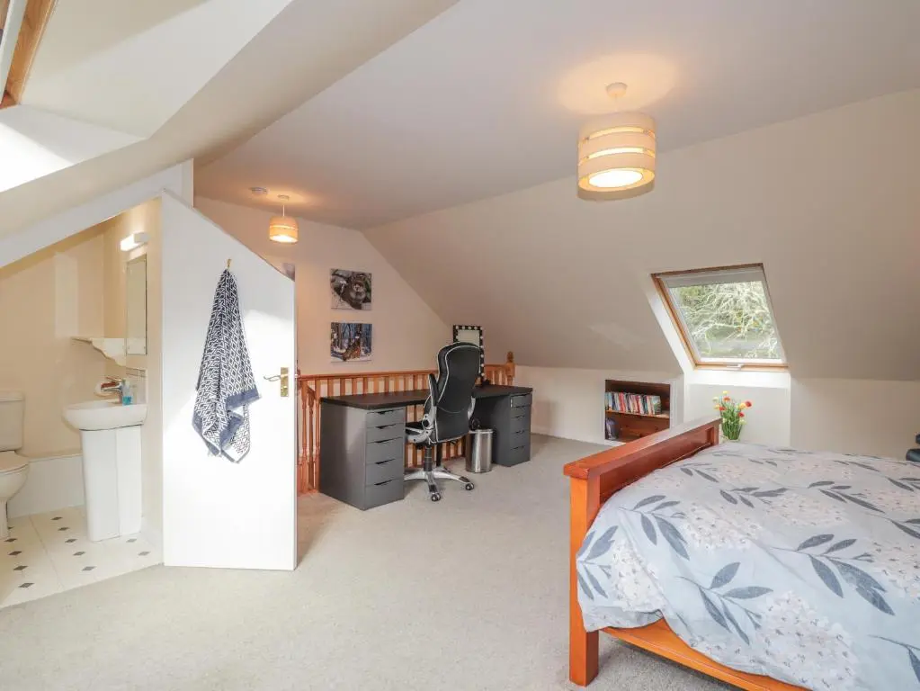 a bedroom with a bed and a desk and a sink at Iola in Inverness