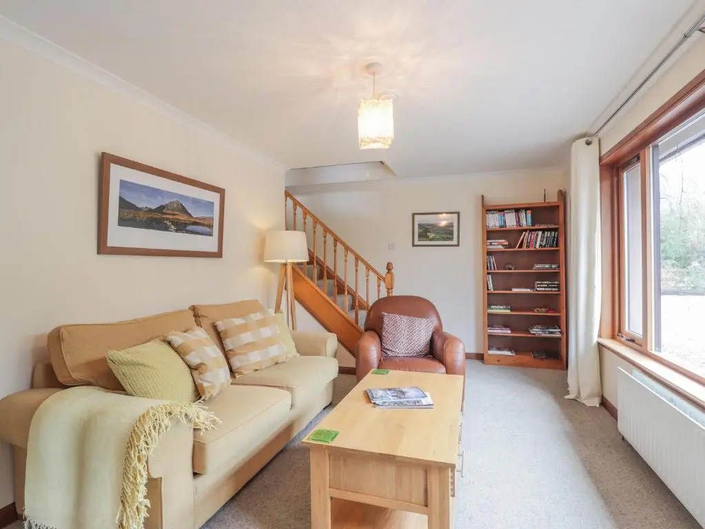 a living room with a couch and a table at Iola in Inverness