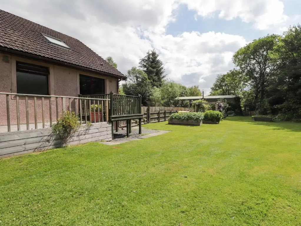 a yard with a bench and a house at Iola in Inverness
