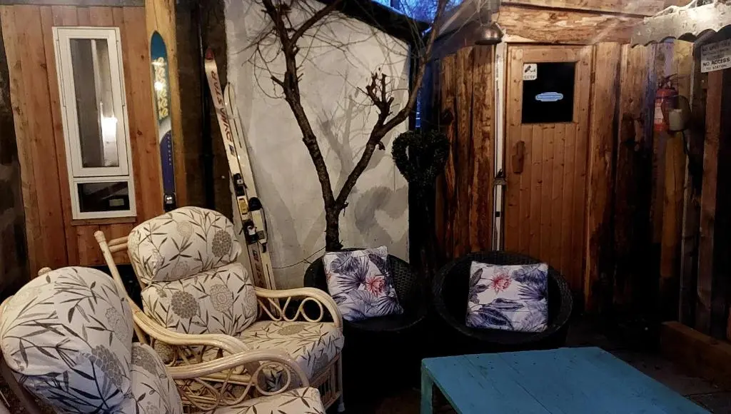 a room with two chairs and a table in a house at Wee Blondie's Ski Cottage in Aviemore