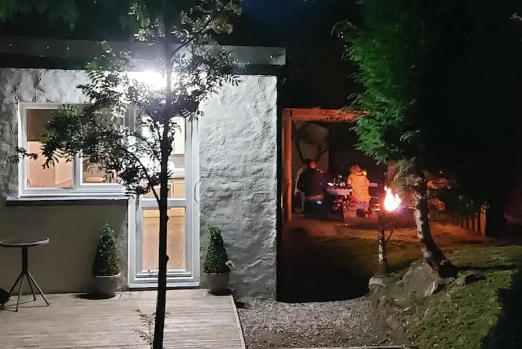 a tree in front of a house at night at Wee Blondie's Ski Cottage in Aviemore