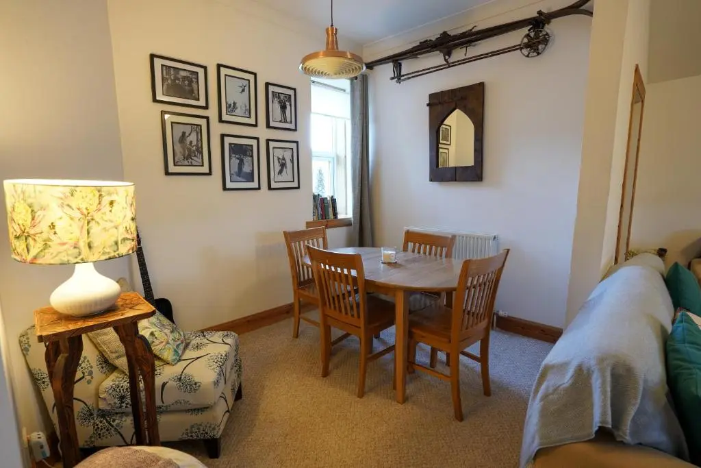 a living room with a table and chairs at Wee Blondie's Ski Cottage in Aviemore