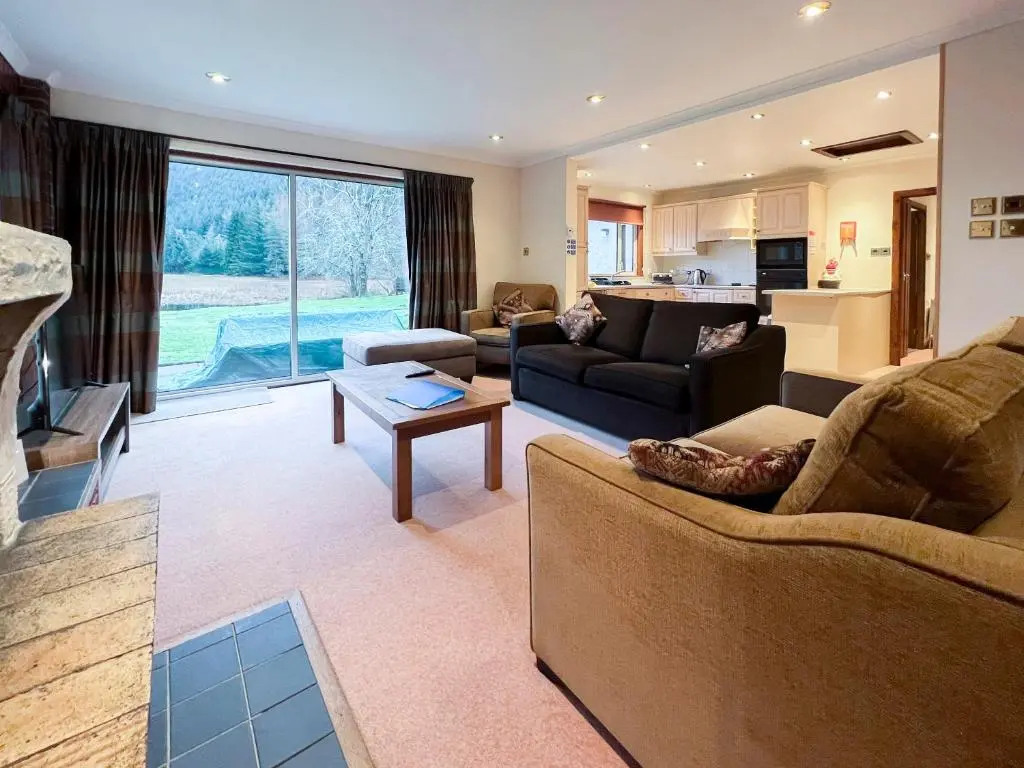 a living room with two couches and a kitchen at Oich View - Uk37554 in Kilfinnan