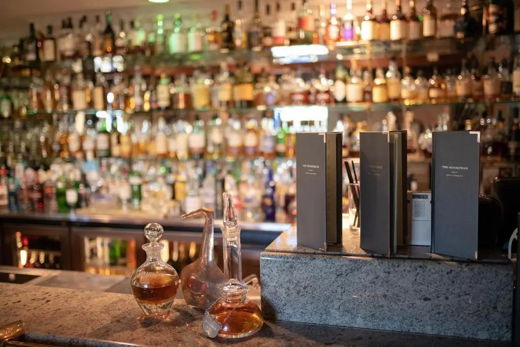 a bar with bottles of alcohol on a counter at The Mansefield Hotel in Elgin