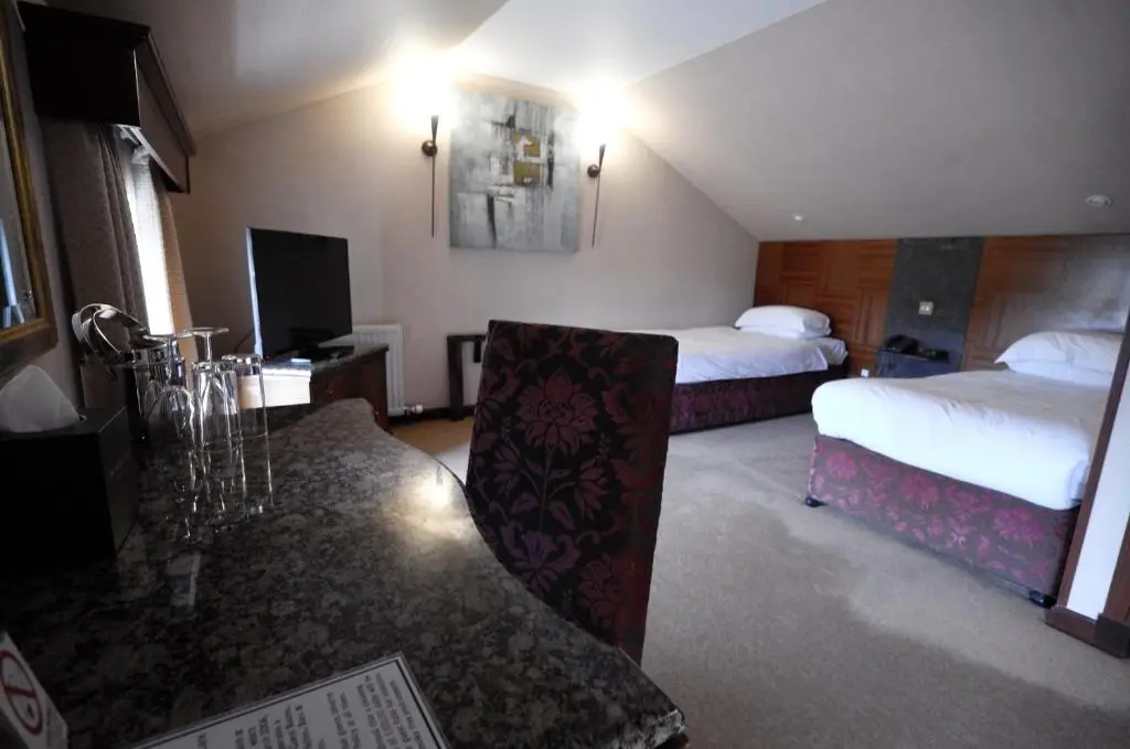 a hotel room with two beds and a table at The Mansefield Hotel in Elgin
