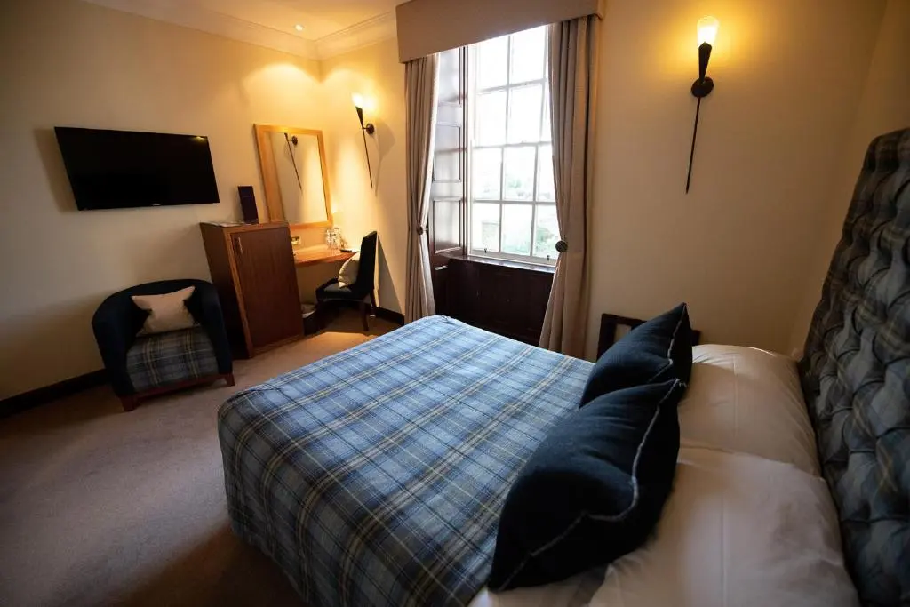 a hotel room with a bed and a window at The Mansefield Hotel in Elgin