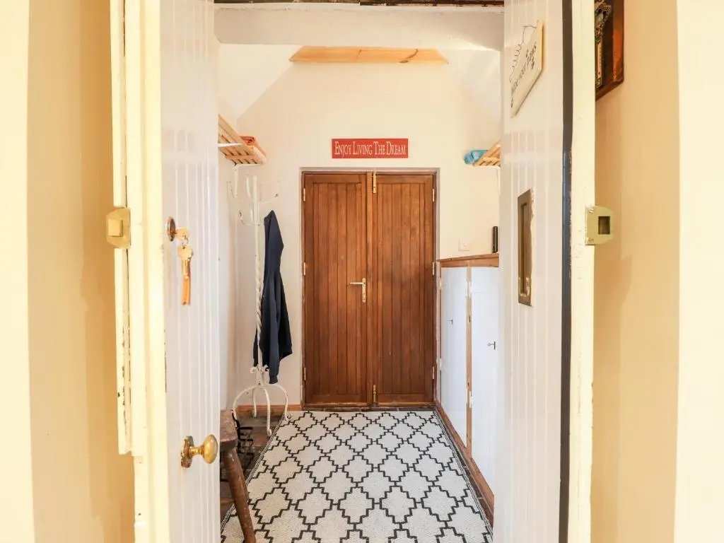 a hallway with a wooden door in a house at Bogindour Cottage in Muir of Ord