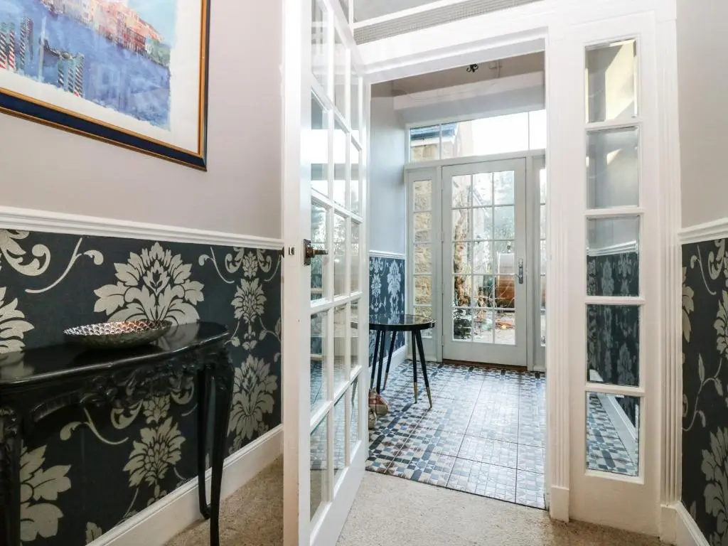 a hallway with black and white wallpaper and a glass door at Mavisbank in Peterhead