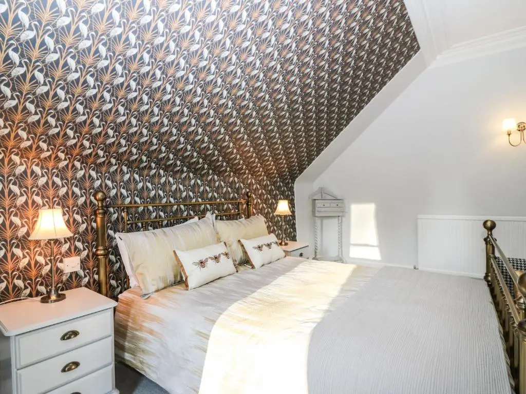 a bedroom with a large bed with a wooden wall at Mavisbank in Peterhead