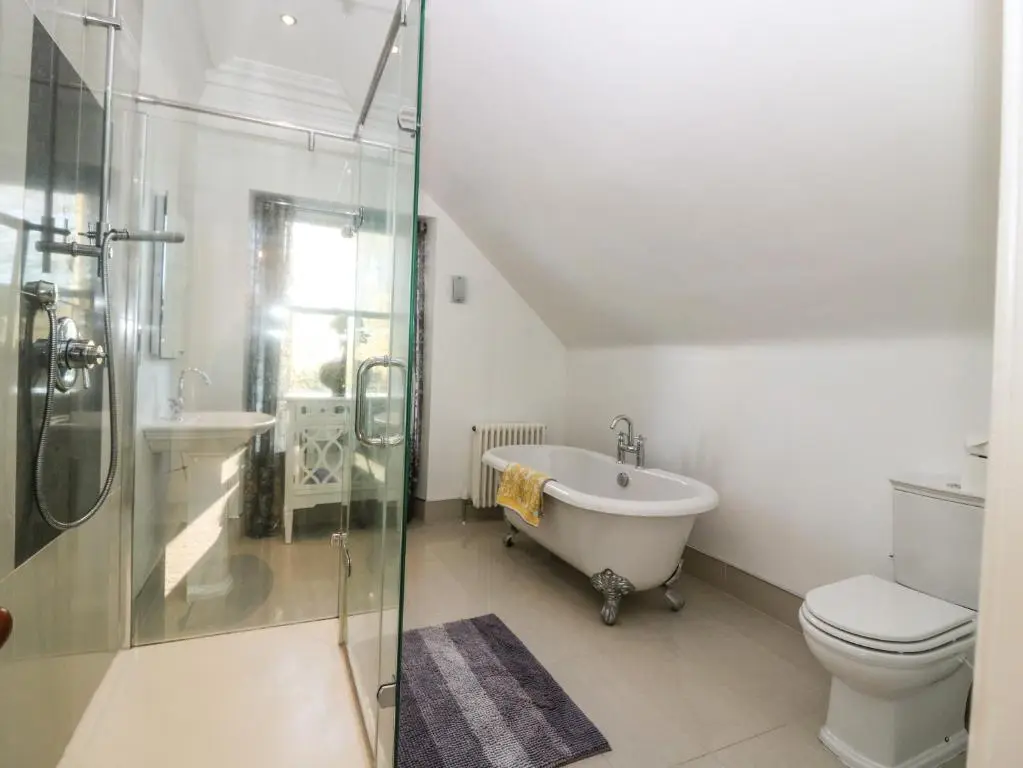 a bathroom with a tub and a toilet and a shower at Mavisbank in Peterhead