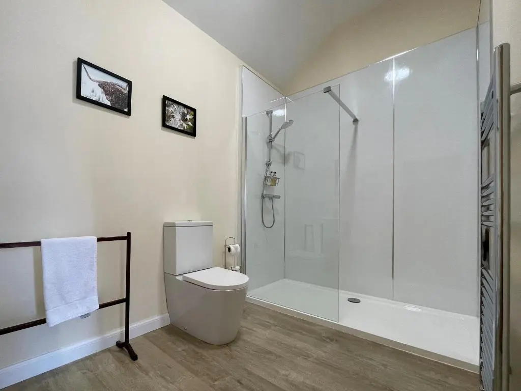 a white bathroom with a shower and a toilet at Farr Out in Farr