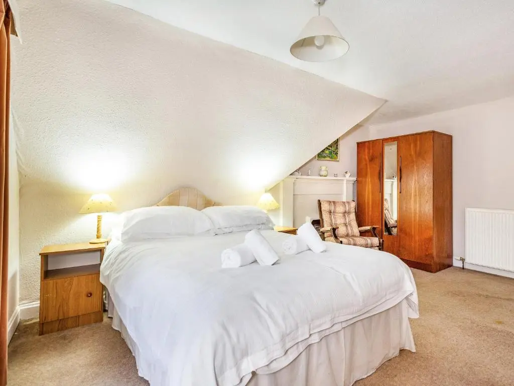 a bedroom with a large white bed with white pillows at Isla Bank Cottage in Keith