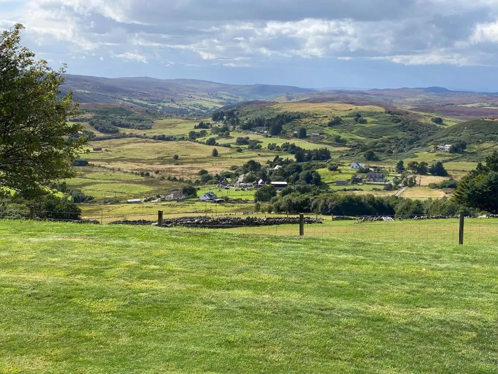 a field of green grass with a view of a valley at Sealladh Mor in Rogart