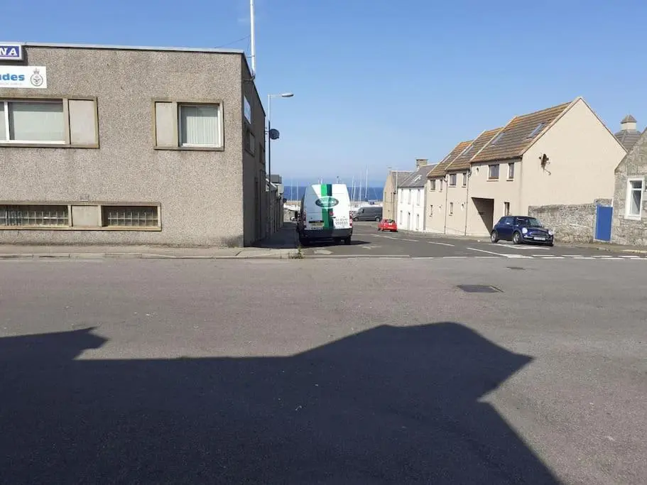 a shadow of a bus parked in a parking lot at Lossiemouth Seaside Flat in Lossiemouth