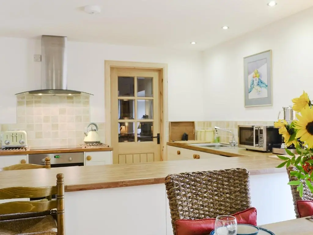a kitchen with a table and a counter top at Paterson Cottage in Tore