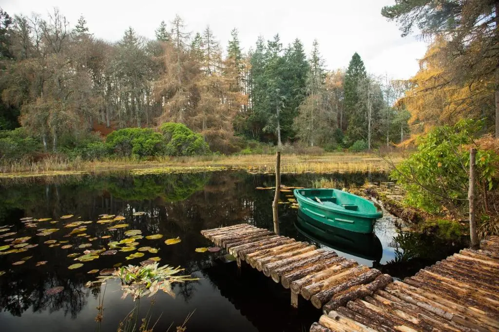 a boat is docked next to a dock on a lake at The Mains in Elgin