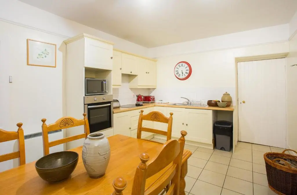 a kitchen with a wooden table and a dining room at The Mains in Elgin
