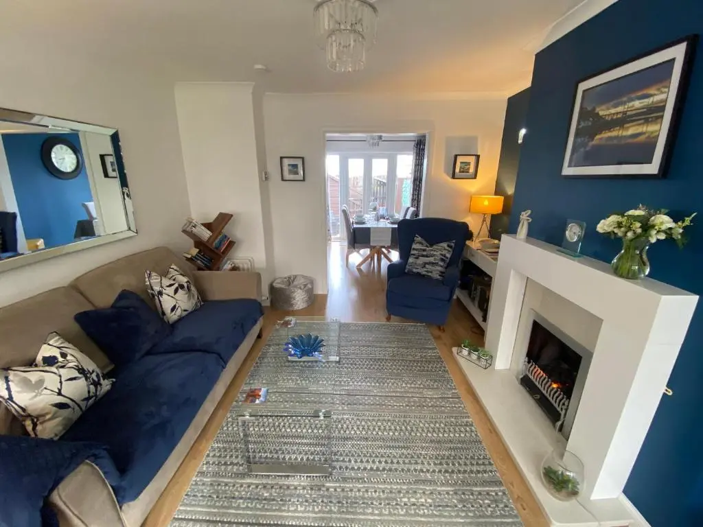 a living room with a couch and a fireplace at Delightful, central 3 bedroom house with garden & free parking in Inverness