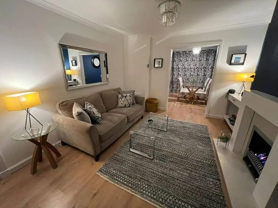 a living room with a couch and a fireplace at Delightful, central 3 bedroom house with garden & free parking in Inverness